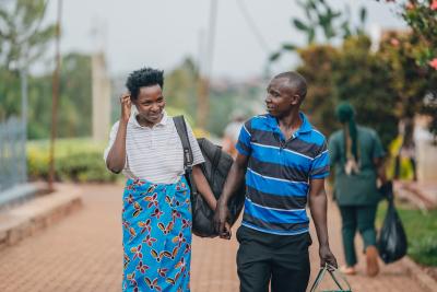 A woman arrives at Kirehe Hospital, supported by her brother, as she prepares to bring new life into the world.
