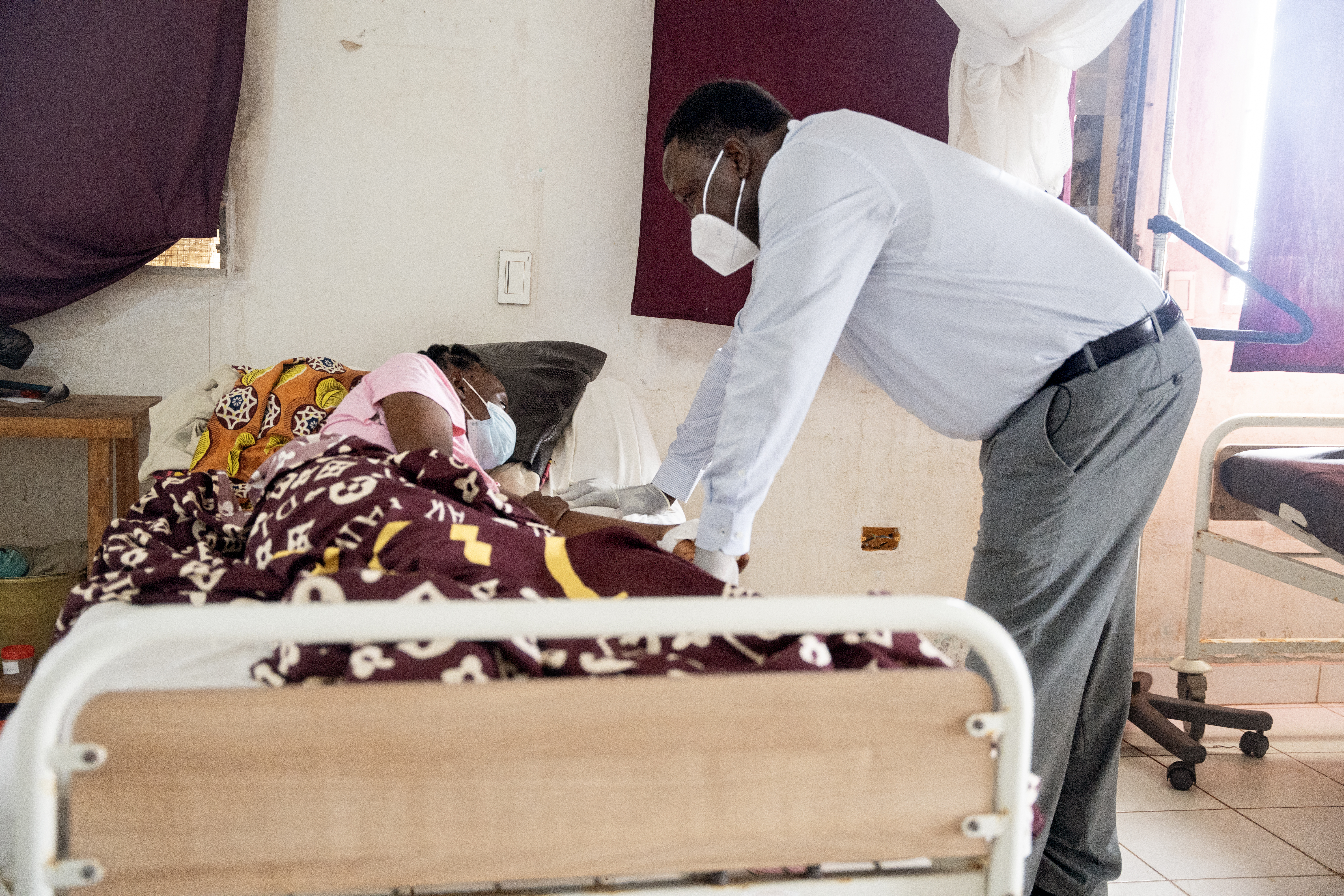 Dr. John Paul Otuba speaking with a patient in the multidrug-resistant tuberculosis ward at J.J. Dossen Memorial Hospital in Liberia