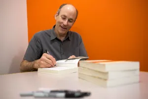 Tracy Kidder signing his book on a white table.