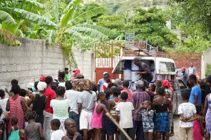 Emergency workers distribute supplies to a crowd in Saint-Marc, Haiti. 
