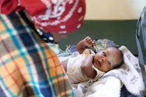 Woman overlooking baby in crib