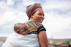 Makatleho Monyake and her 4-month-old baby prepare to ride home on horseback