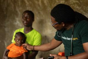 Agatha at her family's home in Putuken, Liberia meeting with a doctor. 