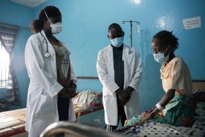 Physician Assistants Theophilus Dolo and Kadiatu A. Konneh follow up with Hawa John, a tuberculosis patient receiving care at a PIH-supported TB clinic in Monrovia, Liberia.