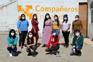 Women wearing face masks posing outside of medical building. 