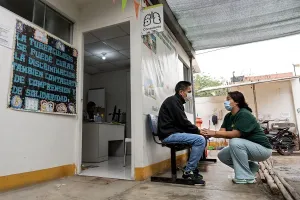 Mary Liz Cuzcano, community health agent, provides support and accompaniment to Jorge Llauri, a 47-year-old patient with multidrug-resistant tuberculosis, at the Raúl Porras Barrenechea Health Center in Carabayllo, Peru. 