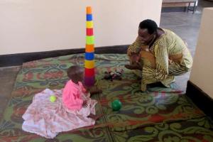 Janet Kayitesi plays with child.