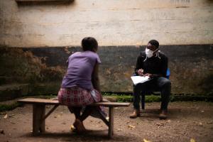 As part of COVID-19 screening and education efforts, a community health worker meets with a patient in Sierra Leone.