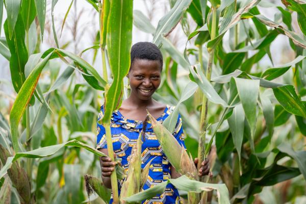 Uwizeyimana Garas stands in a corn field that she helps maintain and harvest as part of the Twigiriricyizere Self-Help Group, a group of 70 mental health patients supported by Partners In Health in Rwanda.