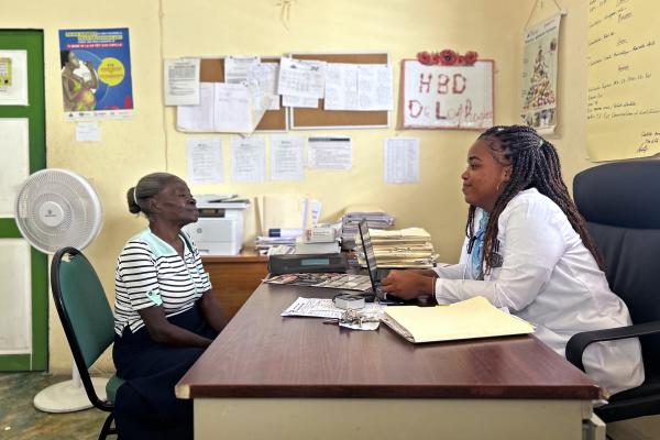 Dr. Stéphanie Laphague (right), head of the TB/HIV program at the Notre Dame de la Nativité Hospital in Belladère, visits with Acefie Théodore (left).