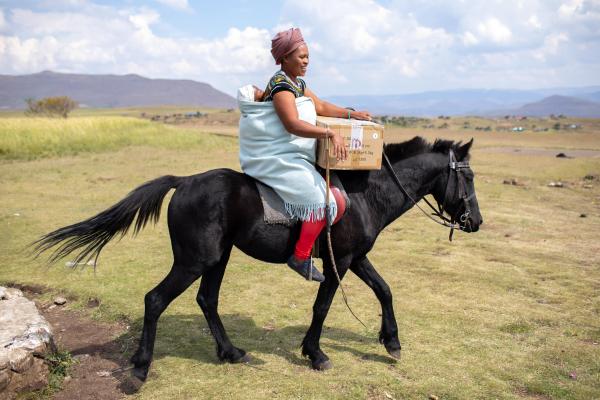 Makatleho Monyake and her 4-month old baby prepare to ride home on horseback with a food package following an appointment at Bobete Health Center in Lesotho.
