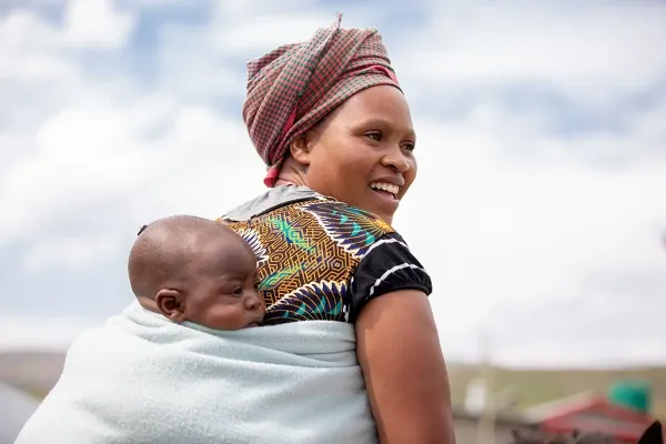 Makatleho Monyake and her 4-month-old baby prepare to ride home on horseback