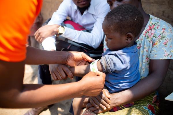 CHW measures arm of child enrolled in the malnutrition program in Malawi. 