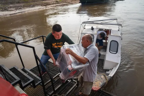 Health workers from Socios En Salud, as Partners In Health is known in Peru, unload equipment to provide free tuberculosis screenings in Loreto, a remote region in the Amazon rainforest.