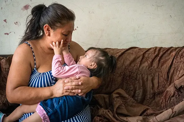 Leidith Tinoco cradles her daughter. 