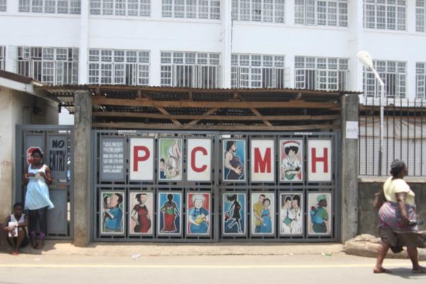 Pedestrians pass the entrance to Princess Christian Maternity Hospital in Freetown, Sierra Leone
