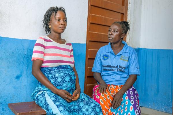 Gladys Abu, a traditional birth attendant, right, accompanies   expecting mother Mary Senesie to Bumpe Community Health Post for an appointment.