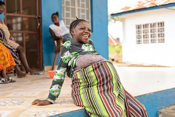 Sia Fengai, 26, sits on the front porch of the maternal waiting home at Wellbody Clinic in Kono District.