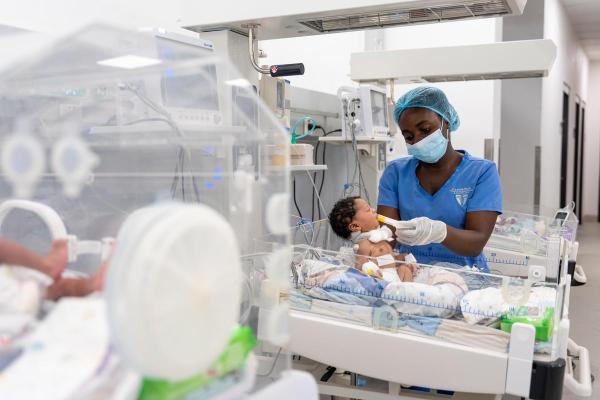 Daniella Jabati, state registered nurse feeds a newborn in the inborn ward of the neonatal intensive care unit at the MCOE.