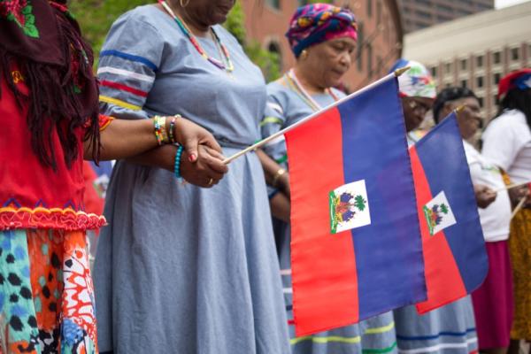 Women hold hands on Haitian Flag Day in downtown Boston, Mass. 