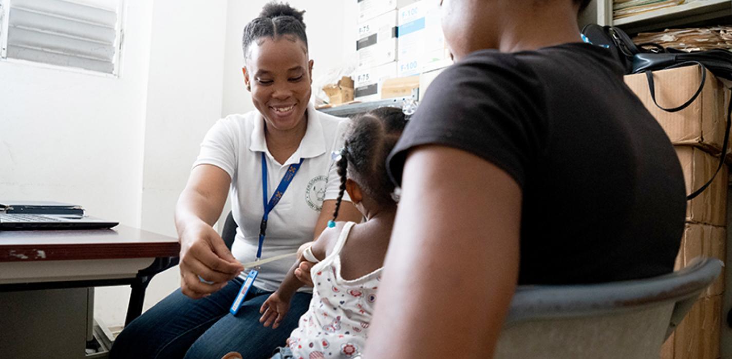 Sandrine Jean, nutrition coordinator, measures a young girl’s arm during a checkup at Hôpital Saint-Nicolas in Saint-Marc, Haiti. 