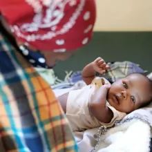 Woman overlooking baby in crib