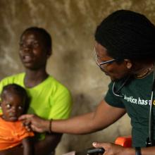 Agatha at her family's home in Putuken, Liberia meeting with a doctor. 