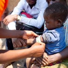 CHW measures arm of child enrolled in the malnutrition program in Malawi. 
