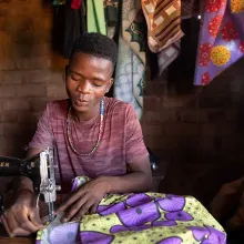 Patrick Francis, a 19-year-old ASPIRE Project participant trained in tailoring, uses his sewing skills to make a living and serve his community. 