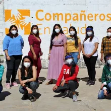 Women wearing face masks posing outside of medical building. 