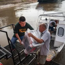 Health workers from Socios En Salud, as Partners In Health is known in Peru, unload equipment to provide free tuberculosis screenings in Loreto, a remote region in the Amazon rainforest.