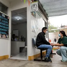 Mary Liz Cuzcano, community health agent, provides support and accompaniment to Jorge Llauri, a 47-year-old patient with multidrug-resistant tuberculosis, at the Raúl Porras Barrenechea Health Center in Carabayllo, Peru. 