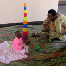 Janet Kayitesi plays with child.