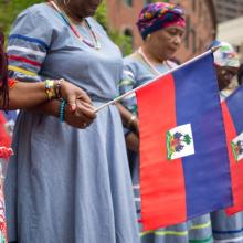 Women hold hands on Haitian Flag Day in downtown Boston, Mass. 