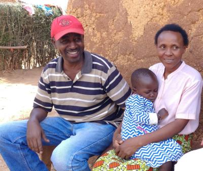 Family sits with program coordinator in Rwanda