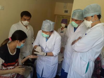 Dr. Yerkebulan Algozhin, endTB/Kazakhstan Team Leader, observes as the first patient takes a dose of new TB drugs in Kazakhstan.