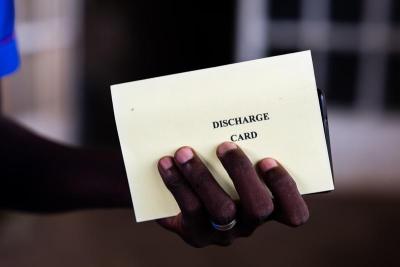 A hand holding a discharge card.