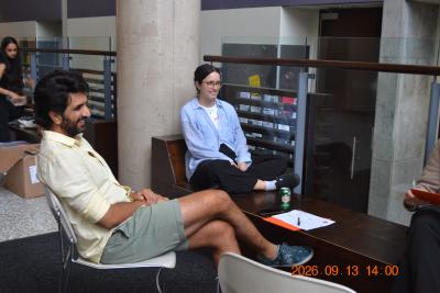 A facilitator and two students sit together in a casual circle during a small group discussion, smiling and engaged in conversation.