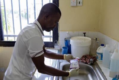 A lab tech at the blood bank handles a bag of blood.