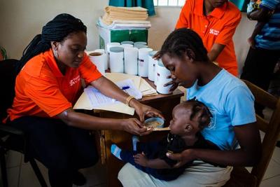 Nutritionist feeding baby in Haiti