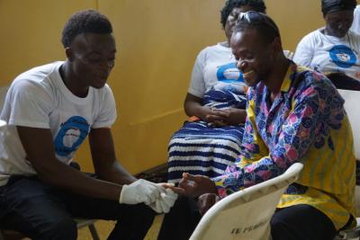 Nurse tests patient's blood sugar level in Liberia