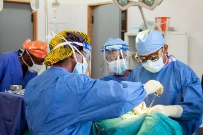 a family medicine resident assists the sole surgeon at PIH-supported J.J. Dossen Hospital in Liberia.