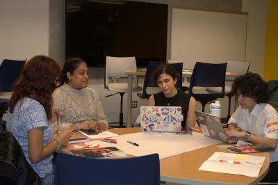 A group of students are seated at a desk.