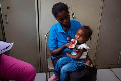 mother feeds daughter during malnutrition visit