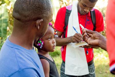 Johnson Guerrier (left) and his 2-year-old daughter, Sarah Guerrier, receive cholera vaccines in Mirebalais, Haiti.
