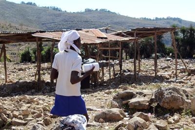 A caregiver in the community of Jeannin in St. Marc collects Nourimanba, a ready-to-use therapeutic food, to bring home for family members.