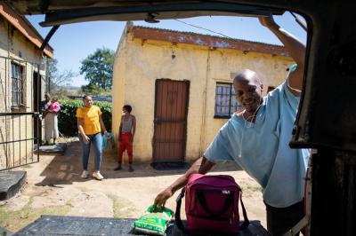 Marumo looks in the truck as he removes a food package from the vehicle.