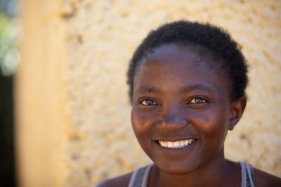 Mokone smiles outside of her home.