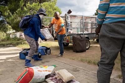 Registered nurse Thuso Ntsapi (right) helps Mokoatsi Mabusela, a treatment supporter, collect food packages for Lekhotla Mkonyana at PIH-supported Nkau Health Center in Lesotho.
