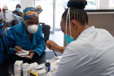 Nurse Mpho Tsibela supplies Masingoaneng Kolosoa, a treatment supporter, with three months worth of medication for Kaizer Mahapa.